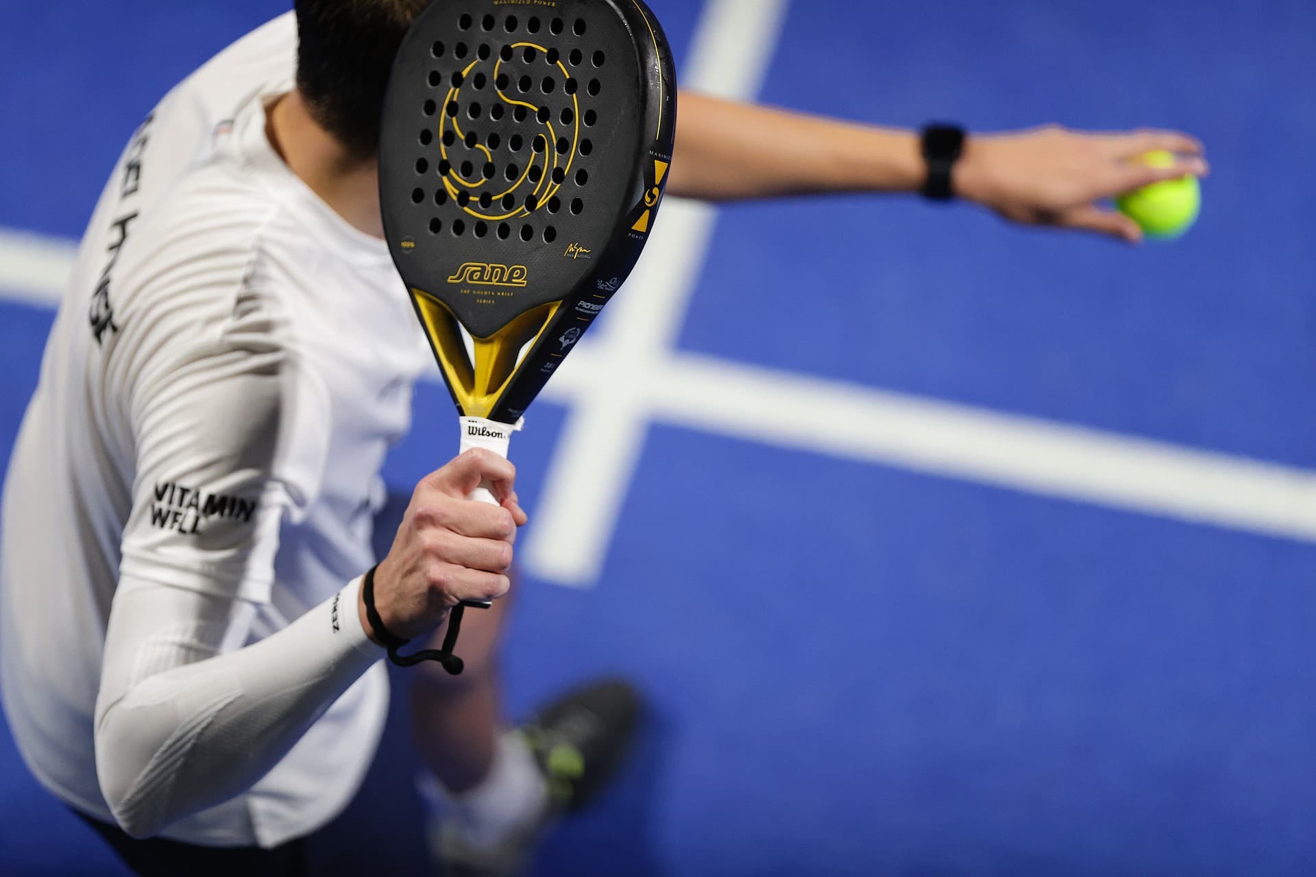Joueur de padel s'apprêtant à servir lors d'un match