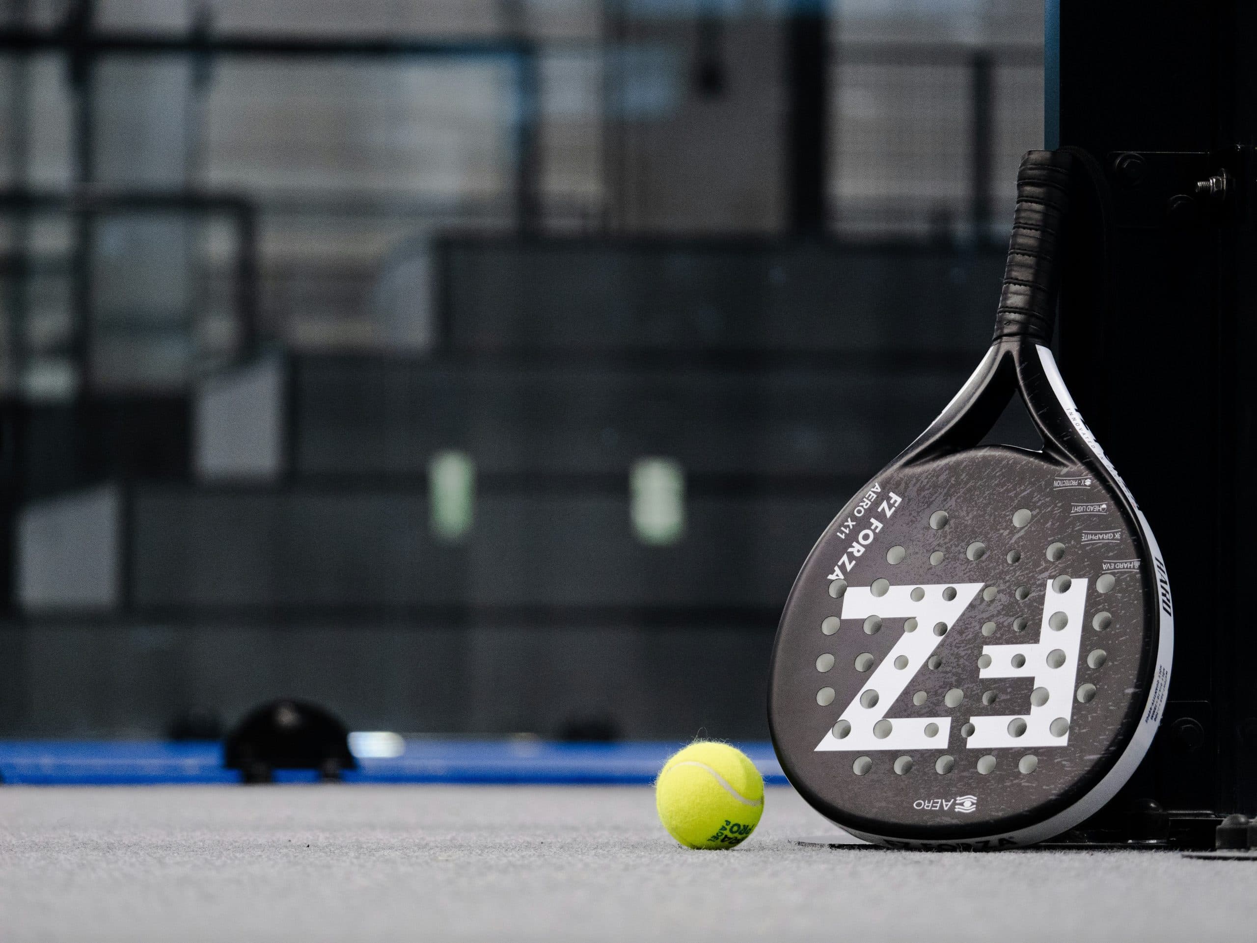 Raquette et ballede padel posée sur un terrain de padel